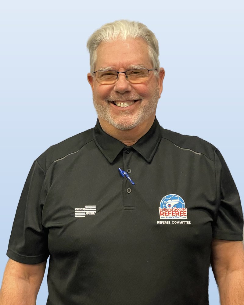 Eric Cox, smiling, in his Referee Committee shirt